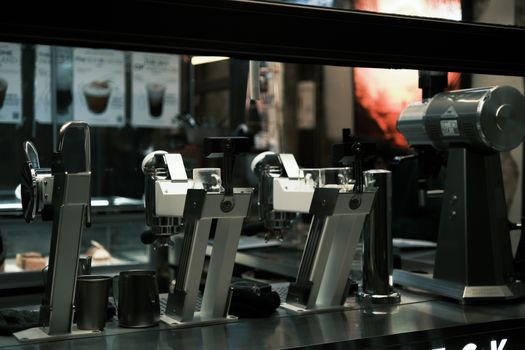 A close-up of modern coffee machines in a bustling café setting, highlighting sleek design.
