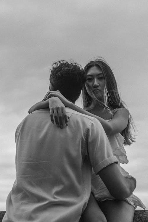 Asian Woman Sitting and Holding a Man in Black and White