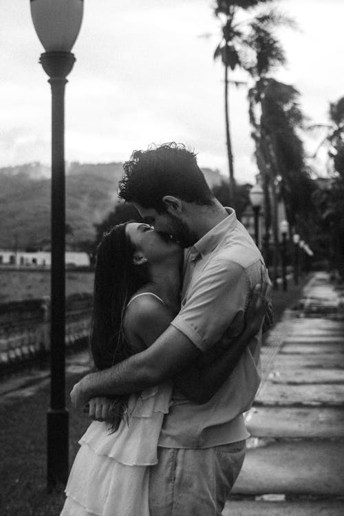 Woman and Man Kissing on the Pavement by the Beach