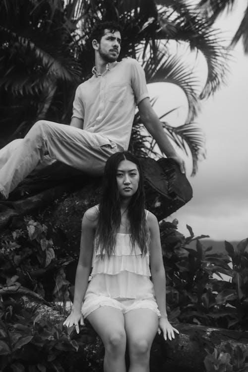 Woman and Man Sitting on the Palm Tree in Black and White