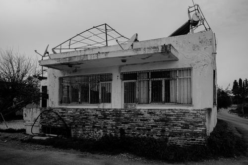 Free A black and white image showcasing an old, abandoned house with a dilapidated roof. Stock Photo