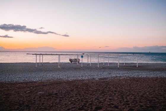 Güneş doğarken yapılarla huzurlu bir plaj manzarası. Huzurlu ve sakin bir atmosfer.