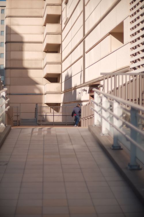 Free Contemporary architecture featuring a pathway with shadows and a solitary figure. Stock Photo