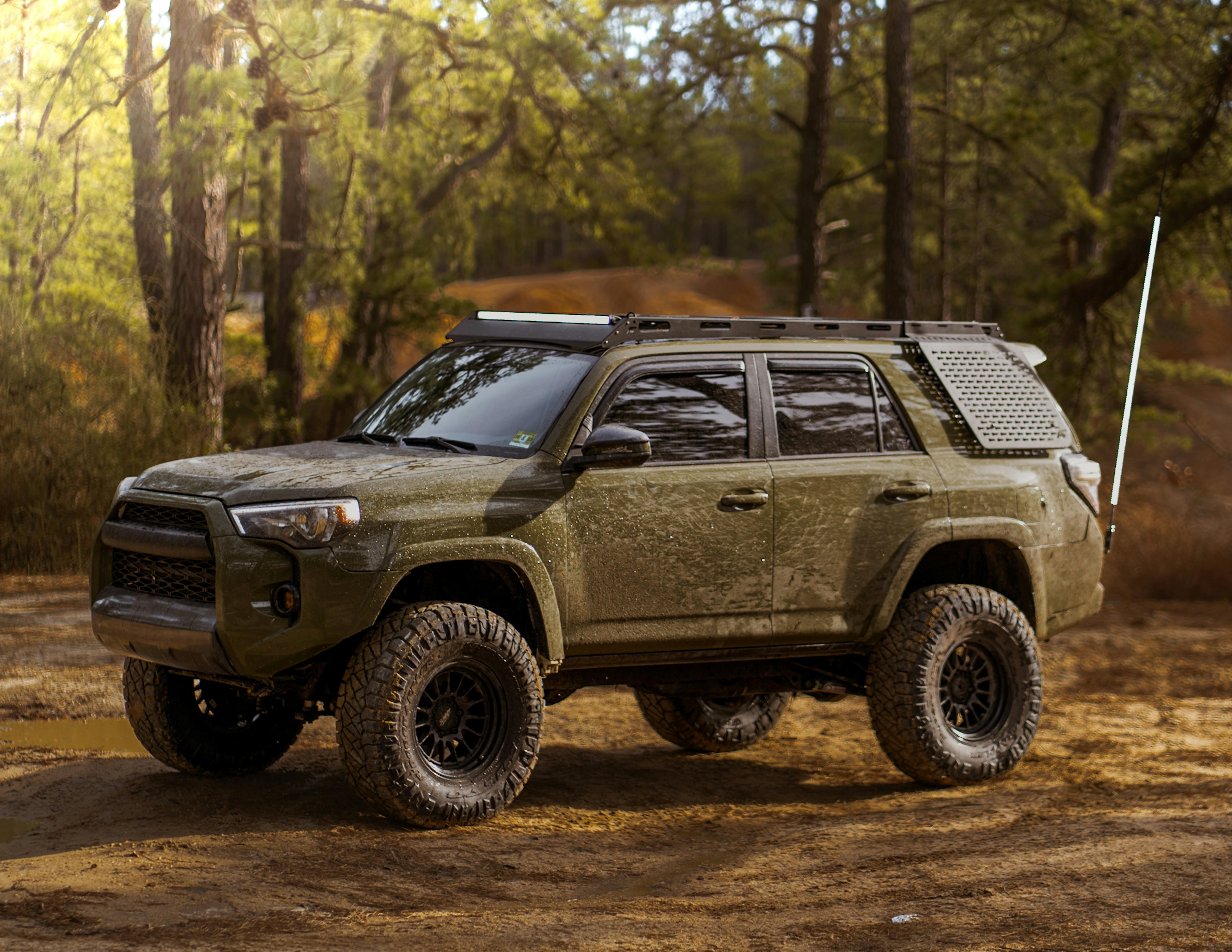 The green toyota 4runner is parked in the woods · Free Stock Photo