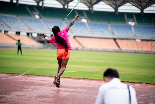 Woman Throwing Javelin on Stadium