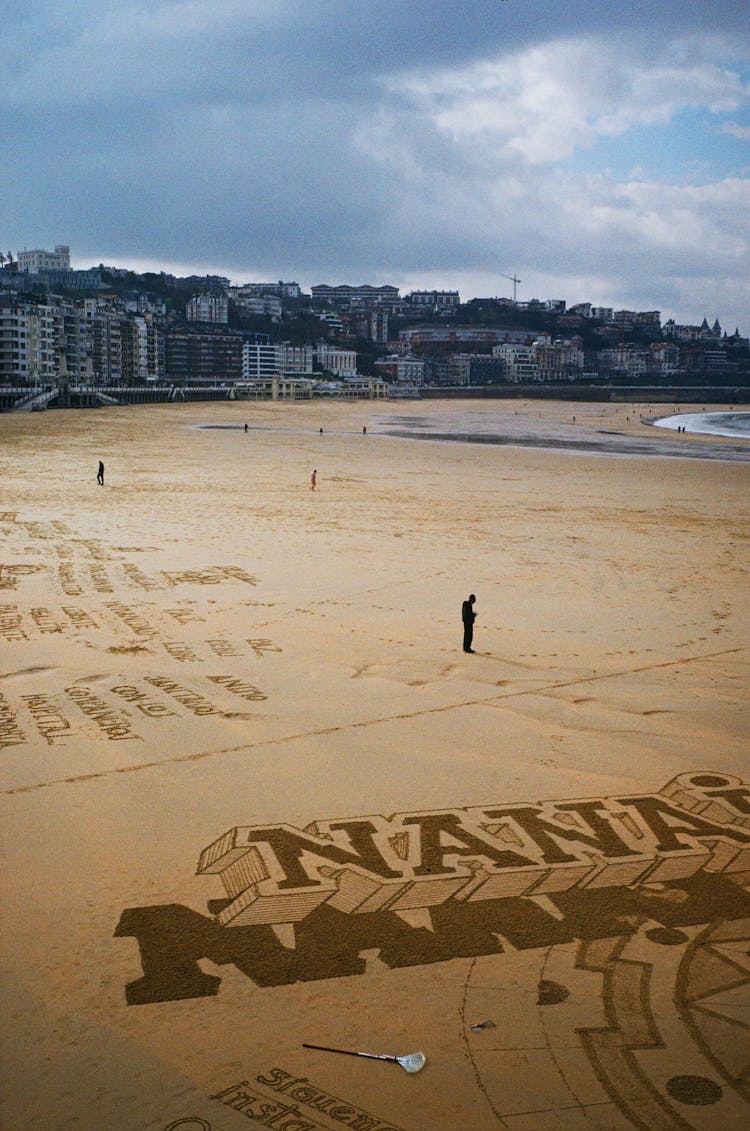 People Creating Patterns In The Sand 