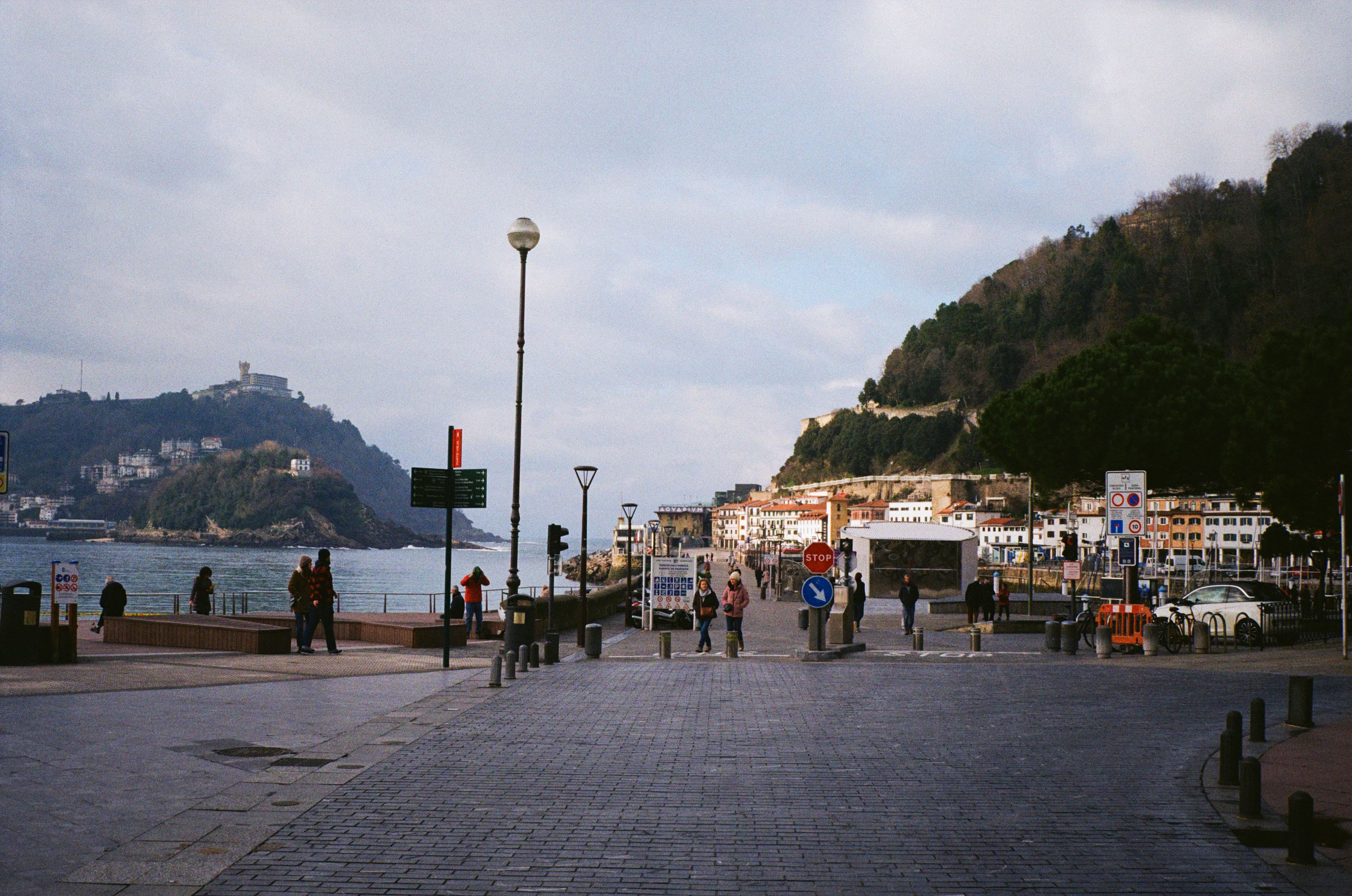 Stunning coastal city promenade with people walking on a cloudy day.
