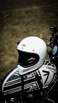 Close-up of a white helmet on a Triumph motorcycle outdoors. Perfect for adventure and motorbike enthusiasts.