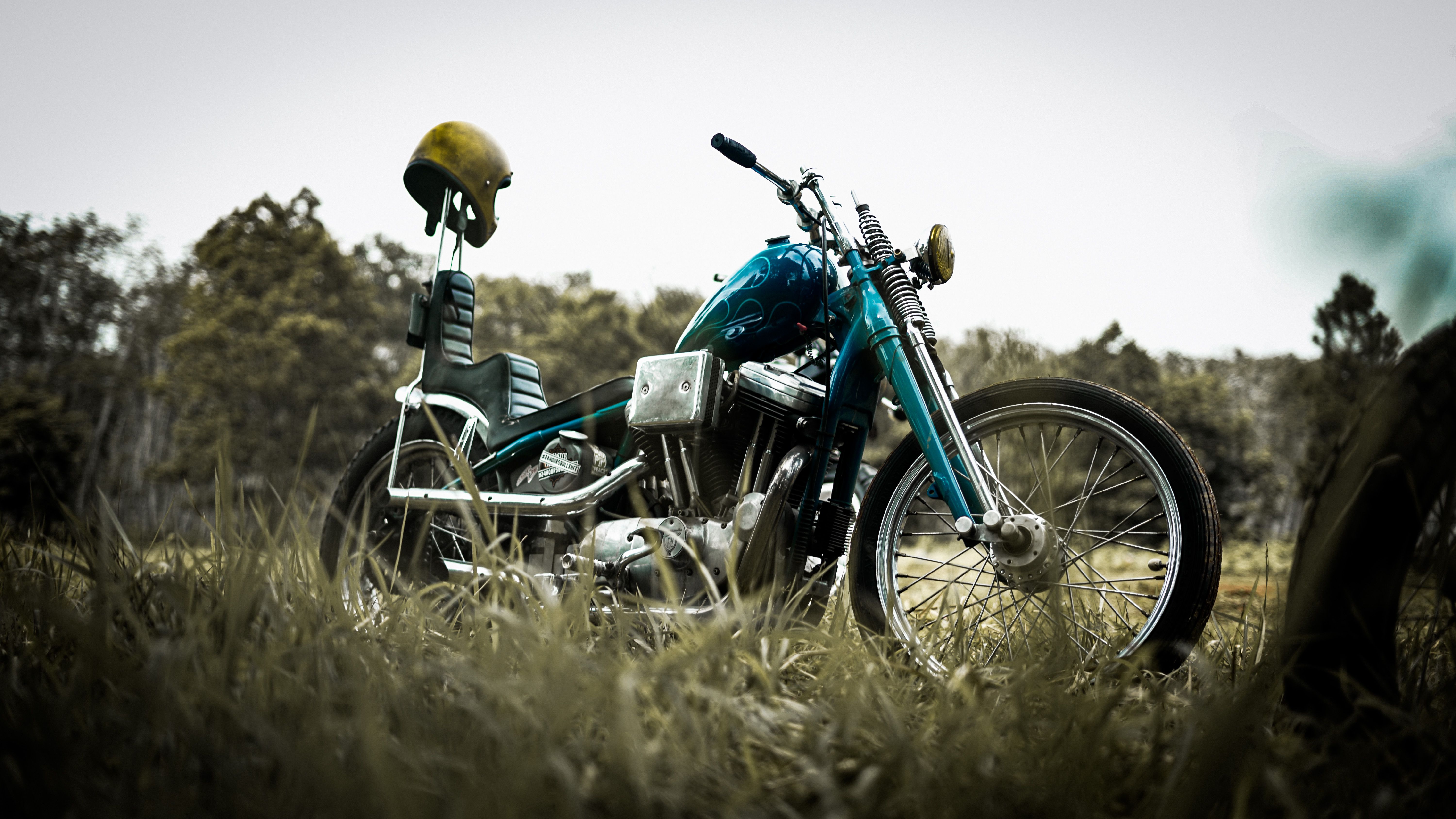 Classic chopper motorcycle parked on a grassy field, embodying freedom and adventure.