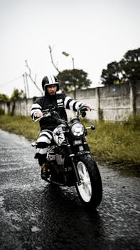 Man in striped outfit riding a motorcycle on a rainy day. Outdoor urban scene.