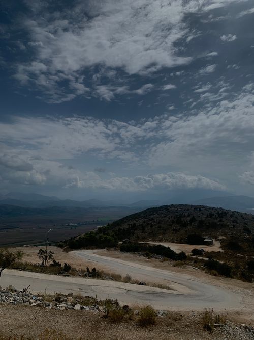 Free Winding road through hills in Sarandë, Albania under a cloudy sky. Stock Photo