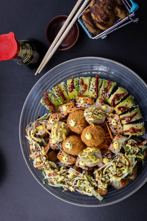Free Colorful sushi platter with avocado and sauces, perfect for a Japanese culinary experience. Stock Photo