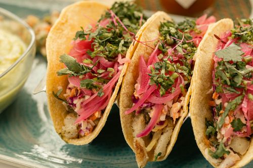 Free Vibrant fish tacos with pickled onions and fresh herbs on a plate. Stock Photo