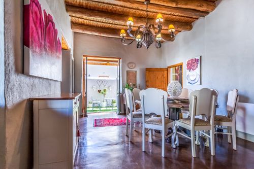 A whitewashed cottage dining room with a beamed ceiling, photo by Jean van der Meulen on Pexels
