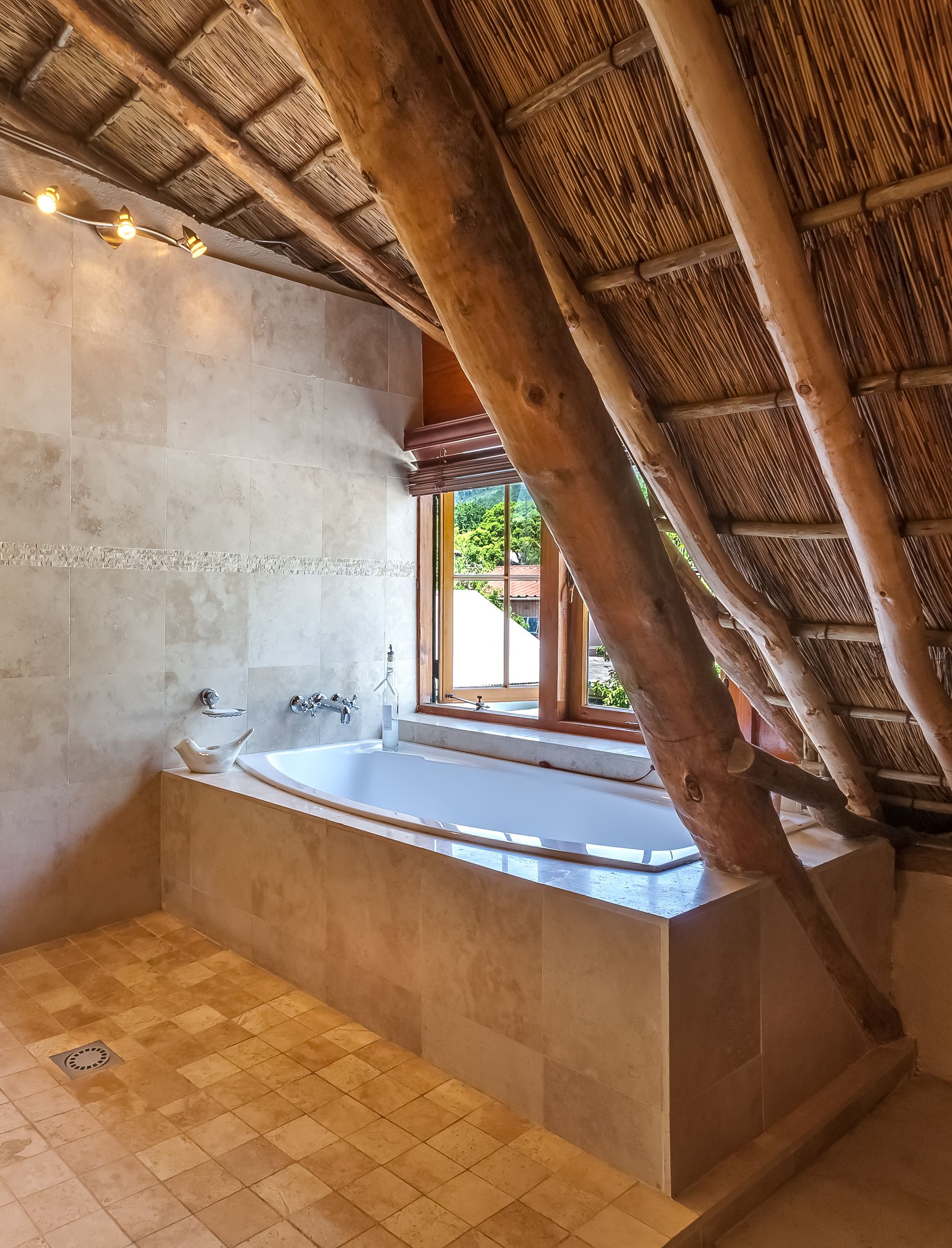 Warm bathroom with visible wood ceiling, pale walls and simple natural materials