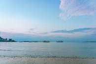 日出时分，宁静的海景与船只，捕捉了平静的水域和充满活力的天空