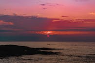 迷人的日落将海洋与地平线染上充满活力的色彩，带来一片宁静