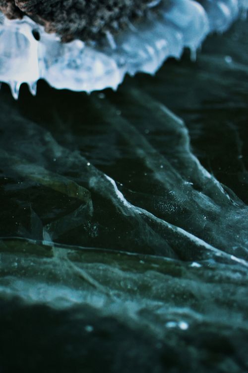 Free Detailed view of icy textures and icicles on a lake during winter, showcasing nature's cold beauty. Stock Photo