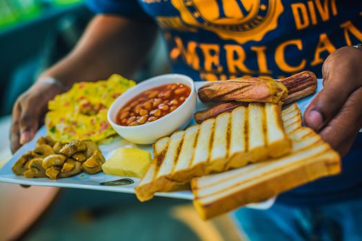 Close-up of an American breakfast platter with beans, toast, and omelette.