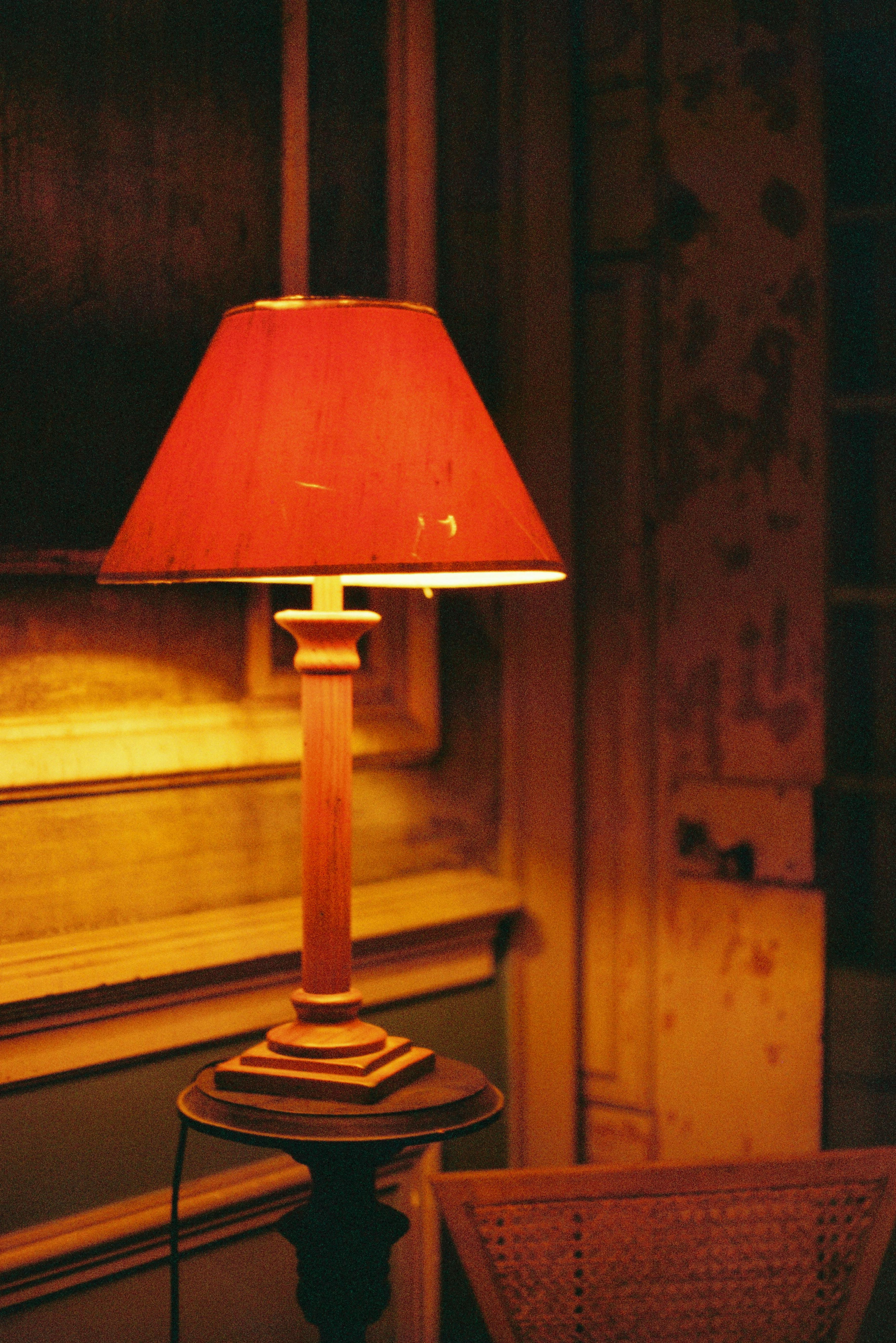 A warm, vintage-style lamp illuminates a rustic room with a soft glow, creating a cozy ambiance.