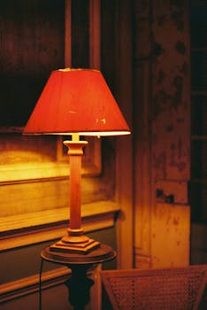 A warm, vintage-style lamp illuminates a rustic room with a soft glow, creating a cozy ambiance.