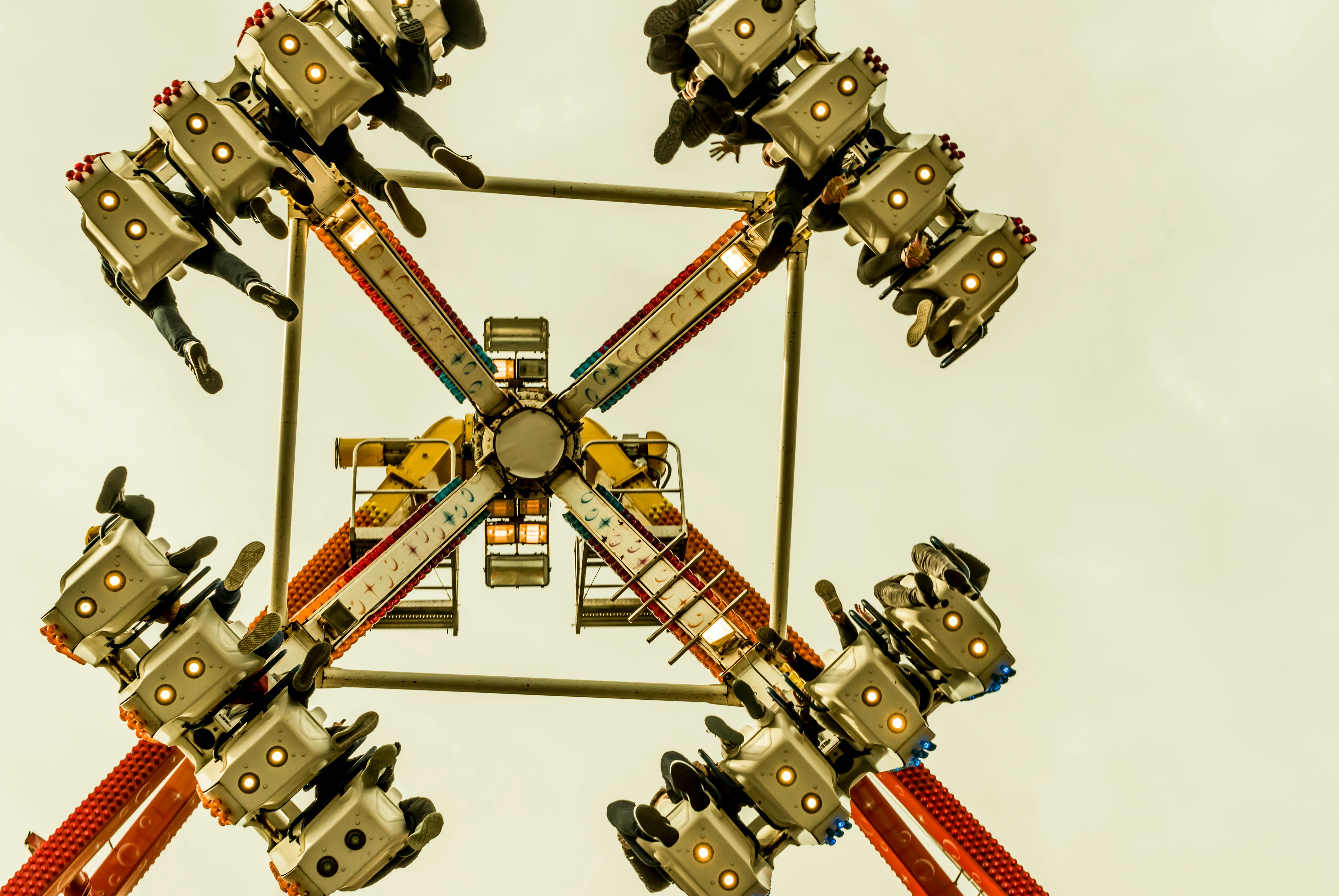 Exciting perspective of a spinning amusement park ride captured from below, highlighting fun and adventure.