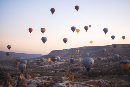 Free A breathtaking view of hot air balloons soaring over Cappadocia during sunset in Nevşehir, Türkiye. Stock Photo