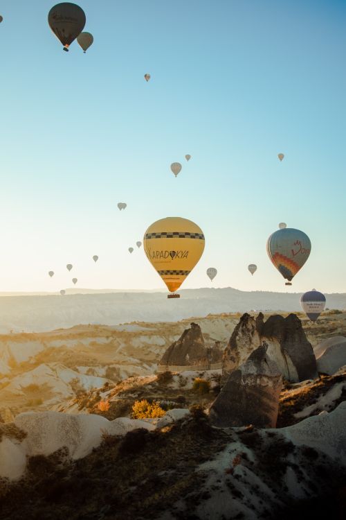 Free Scenic hot air balloons floating over the rock formations in Cappadocia at sunrise, Turkey. Stock Photo