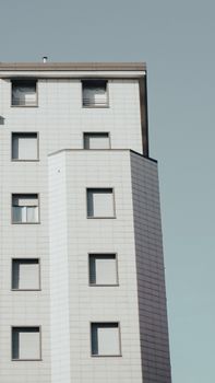 Side view of a modern minimalist apartment building with a light facade.