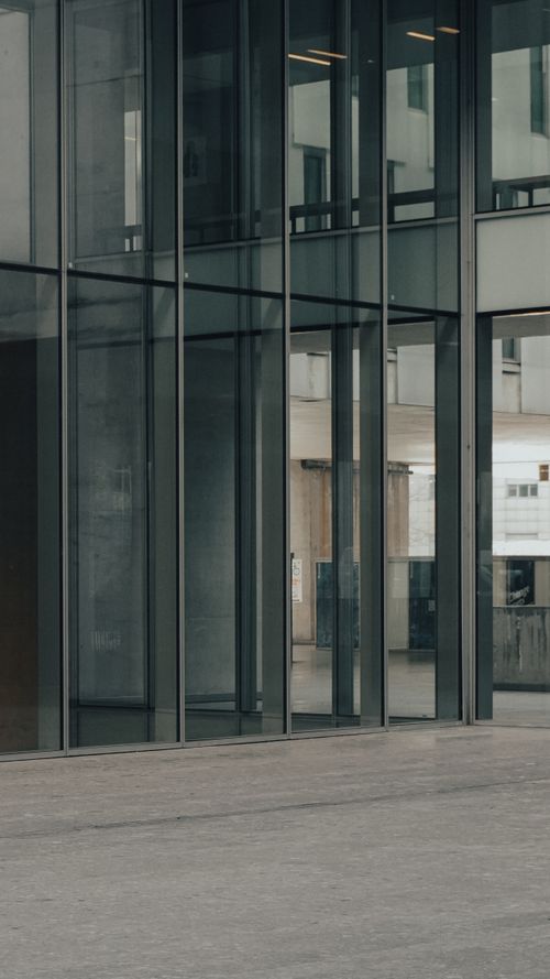 Free Sleek modern architecture with glass facade in an urban setting, showcasing reflective surfaces. Stock Photo