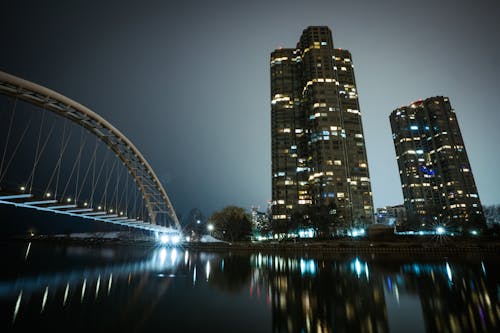 Skyscrapers near Illuminated Bridge at Night