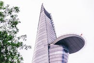 从一个低角度捕捉，一栋采用未来主义玻璃与钢材设计的现代摩天大楼