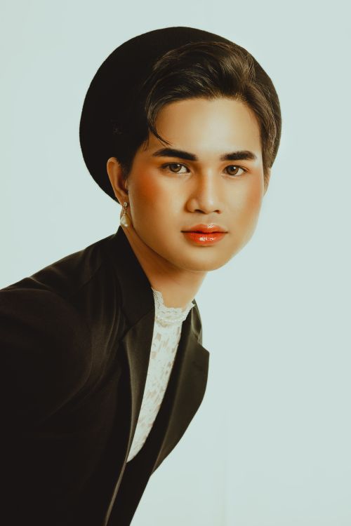 Free Elegant fashion portrait of an adult wearing a black beret and blazer against a neutral background. Stock Photo