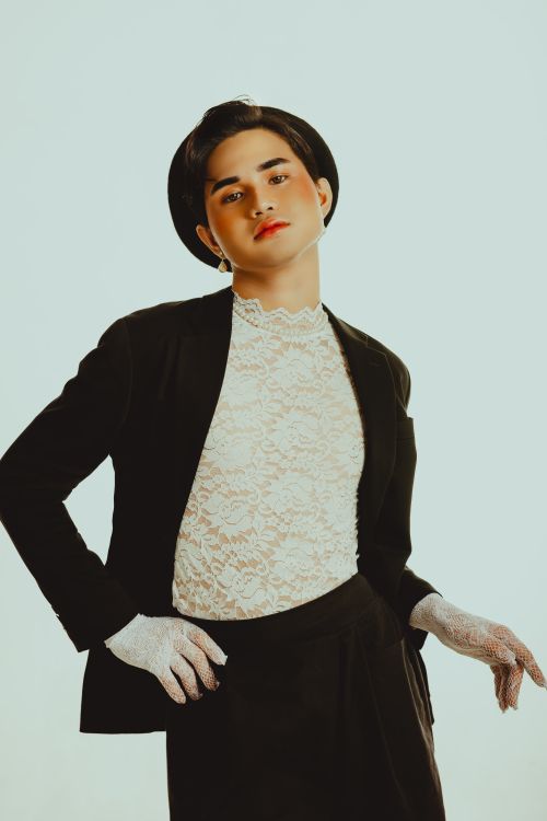 Free Stylish fashion portrait of a man in black suit and lace top, wearing a hat and gloves. Stock Photo