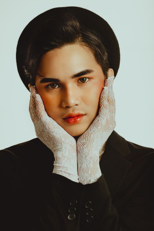 Free Stylish studio portrait of a man in lace gloves and hat on a white background. Stock Photo