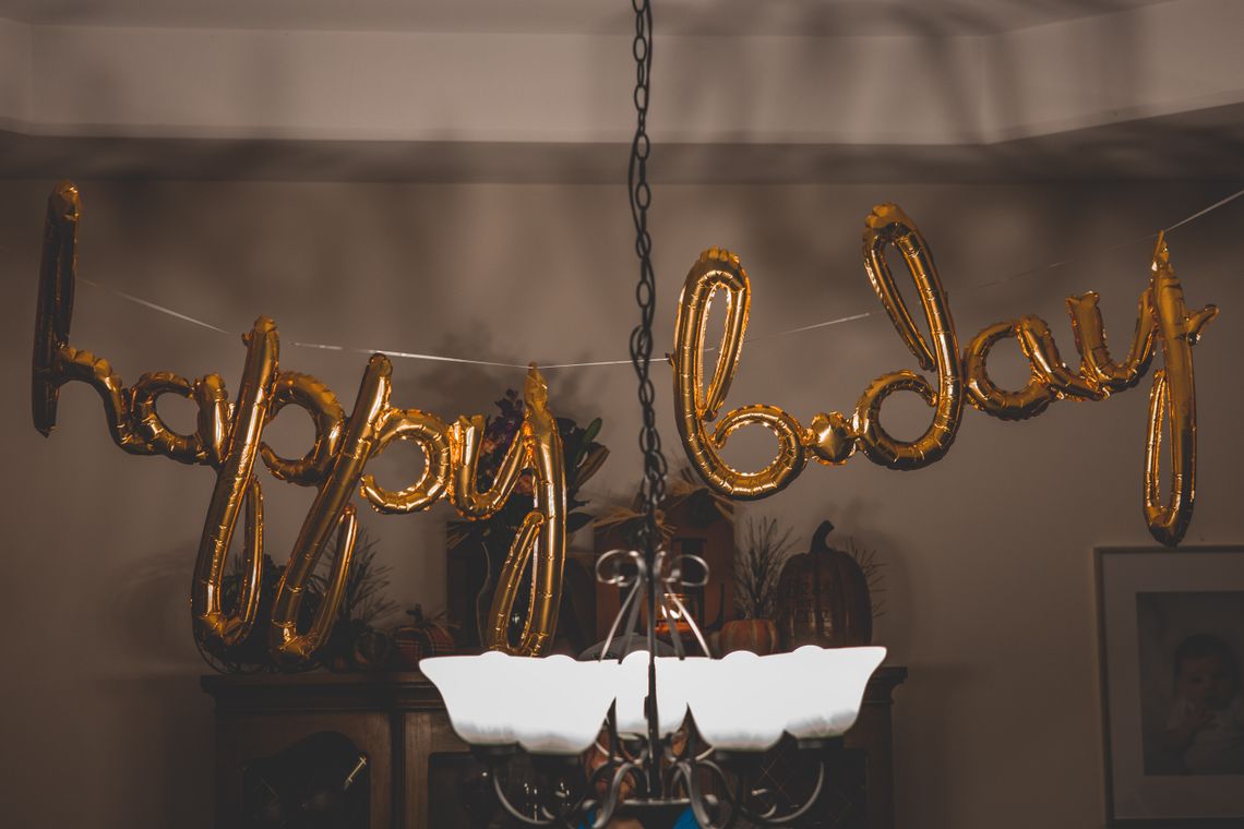 Celebration table with flowers, balloons, wrapped gifts, and colorful party styling