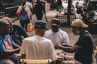 一群老人在街边的桌子上打牌，享受着休闲时光，也展现了社区生活的温馨