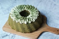 质朴的板上放着美味的抹茶蛋糕，上面点缀着鲜奶油