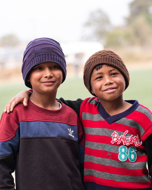 Free Happy portrait of two boys embracing with winter hats outdoors. Stock Photo