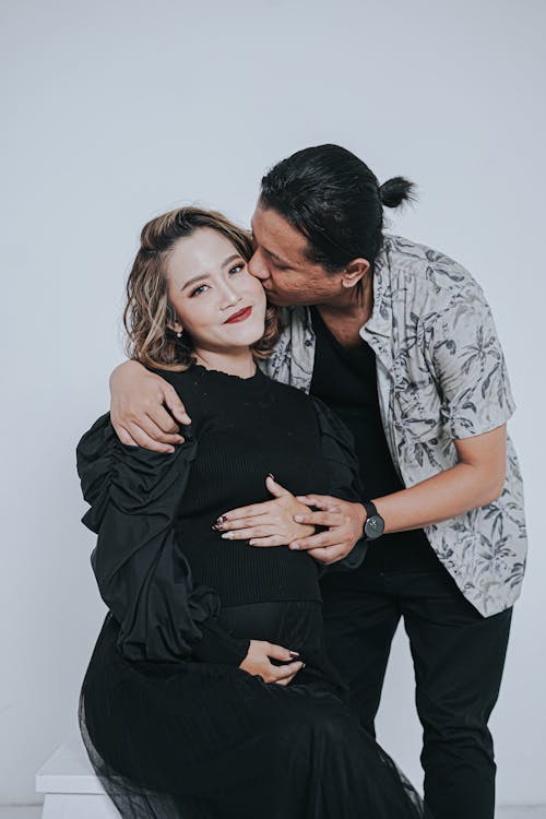 Man Hugging and Kissing Woman in Black Clothes