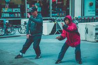 两个成年人在城市街头的环境中练习武术，展示健身与专注