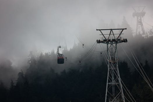 Gondola traveling through misty forested mountains in Vancouver, creating a moody atmosphere