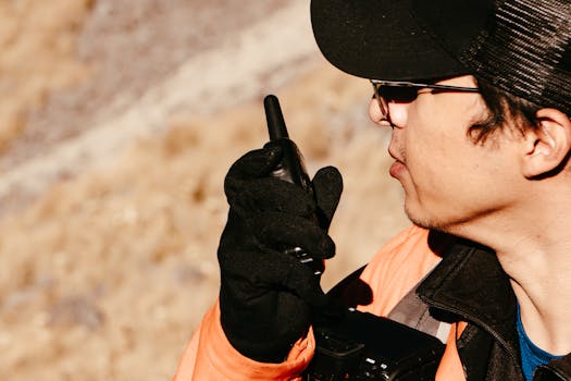 Close-up of a man using a walkie talkie outdoors. Perfect for security and communication themes.