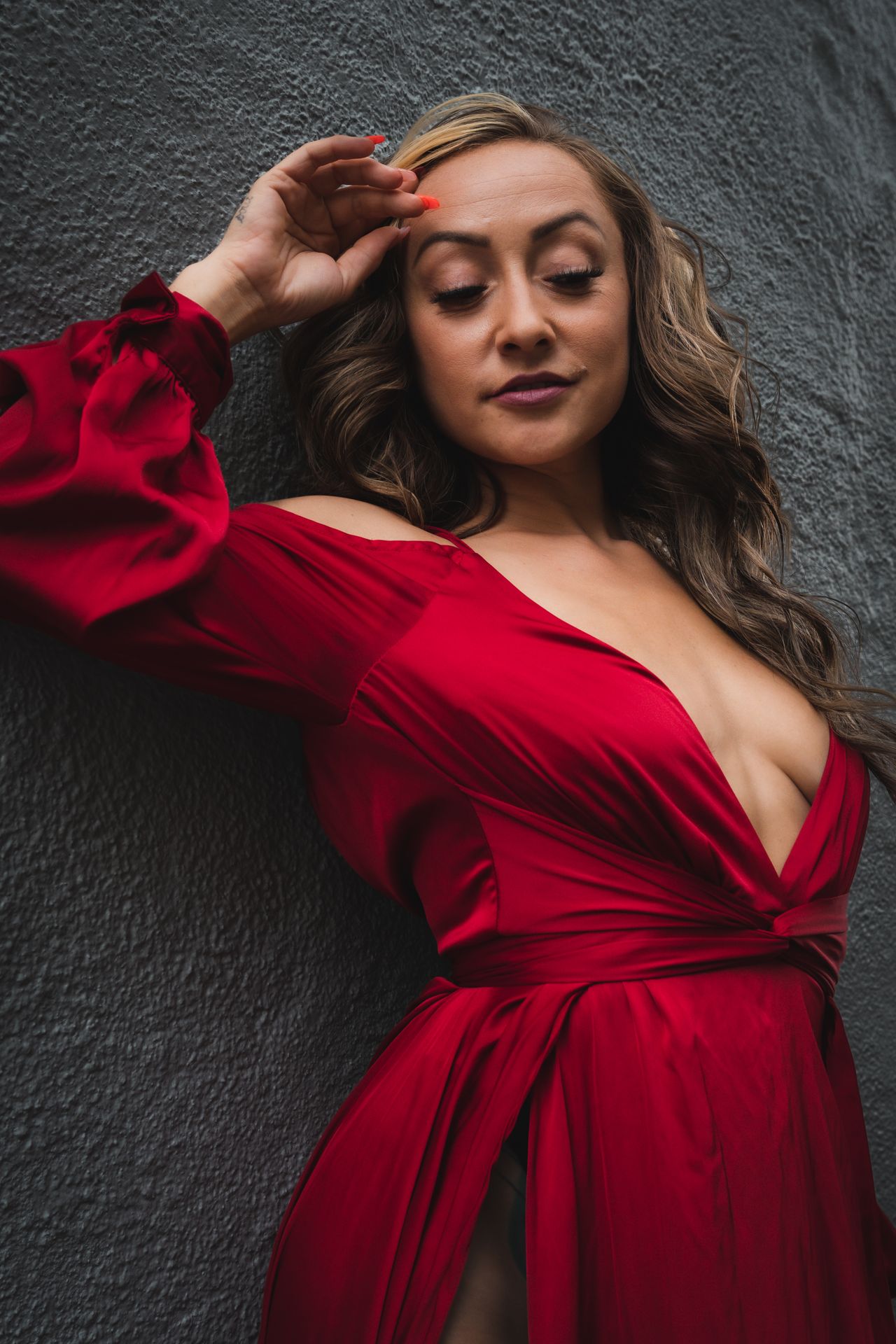 Woman in a deep red wrap dress with long sleeves, a timeless red dress outfit with nude heels