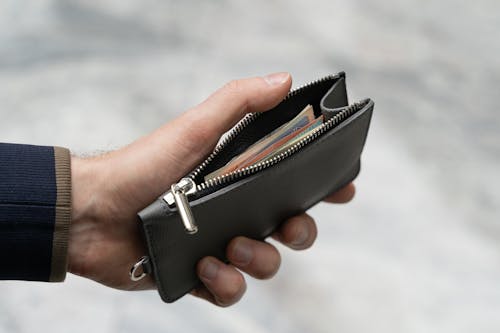 Close-Up Shot of a Person Holding a Leather Wallet with Money