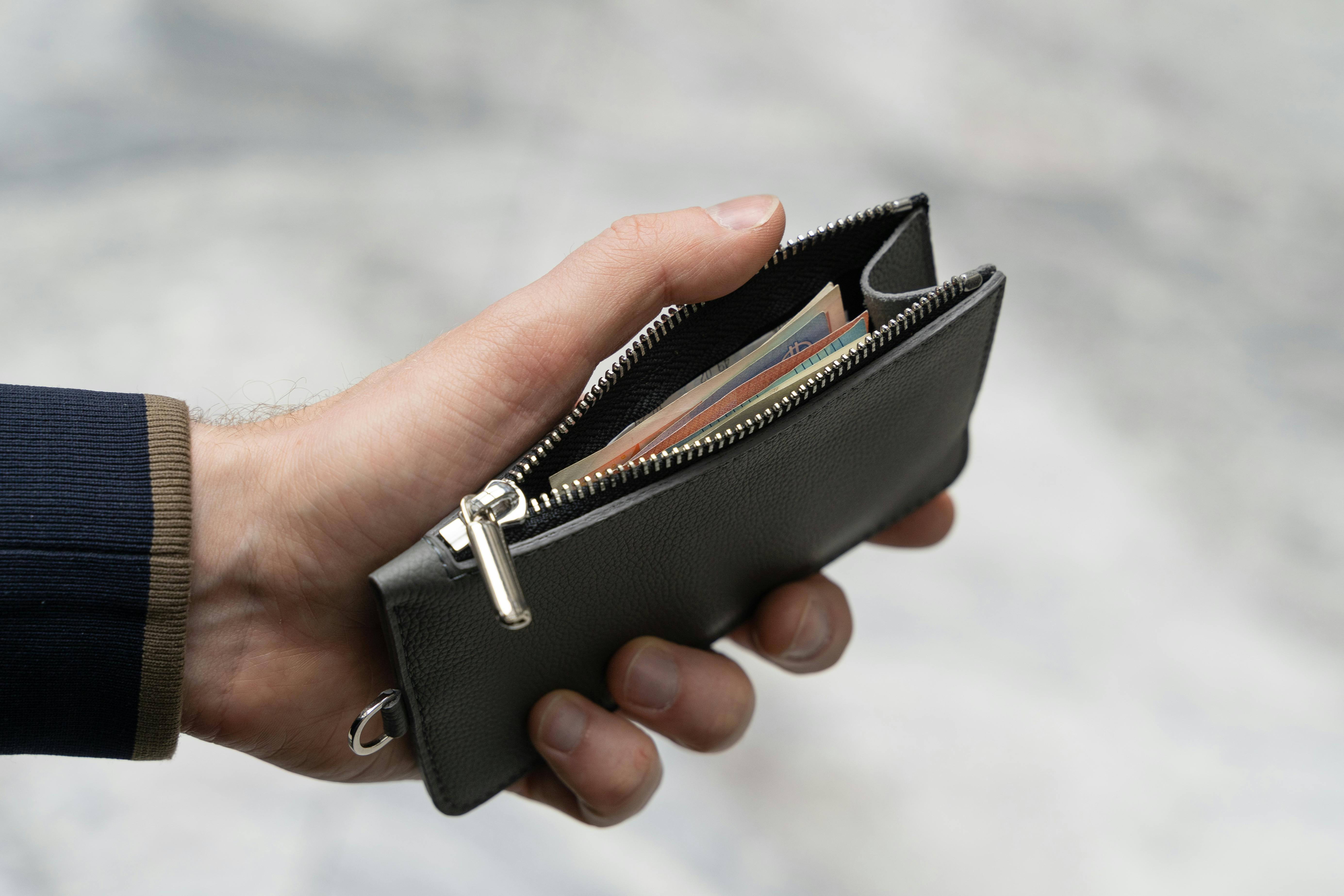 Free Close-Up Shot of a Person Holding a Leather Wallet with Money Stock Photo