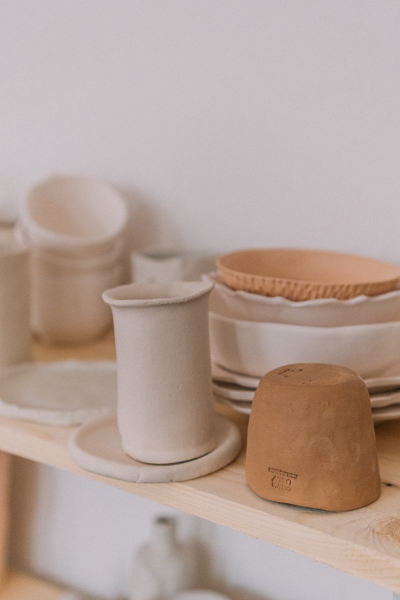 Pale stoneware vessels grouped on a plain surface