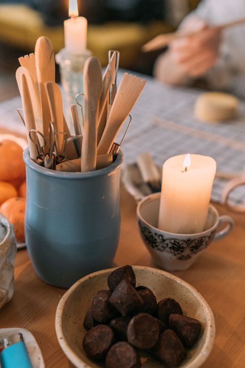 Free Warm table setting with candlelight, wooden utensils, clementines, and chocolate treats. Stock Photo
