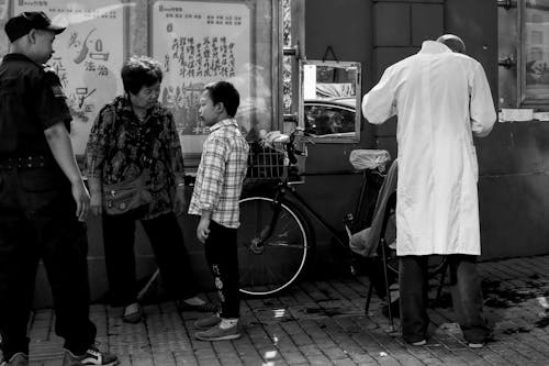 Group of People Standing on a Sidewalk in City 