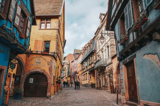Vibrant cobblestone street in Colmar, France, showcasing colorful historic buildings.